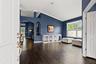 Step inside to a bright, open interior where high ceilings and rich flooring immediately create a sense of space.