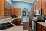 The kitchen offers abundant wood cabinetry, generous counter space, stainless appliances, and plenty of room for everyday meal prep.