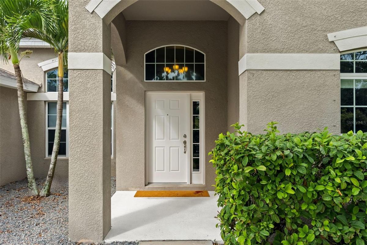 The covered front entry creates a welcoming arrival, with an arched transom bringing additional natural light inside.