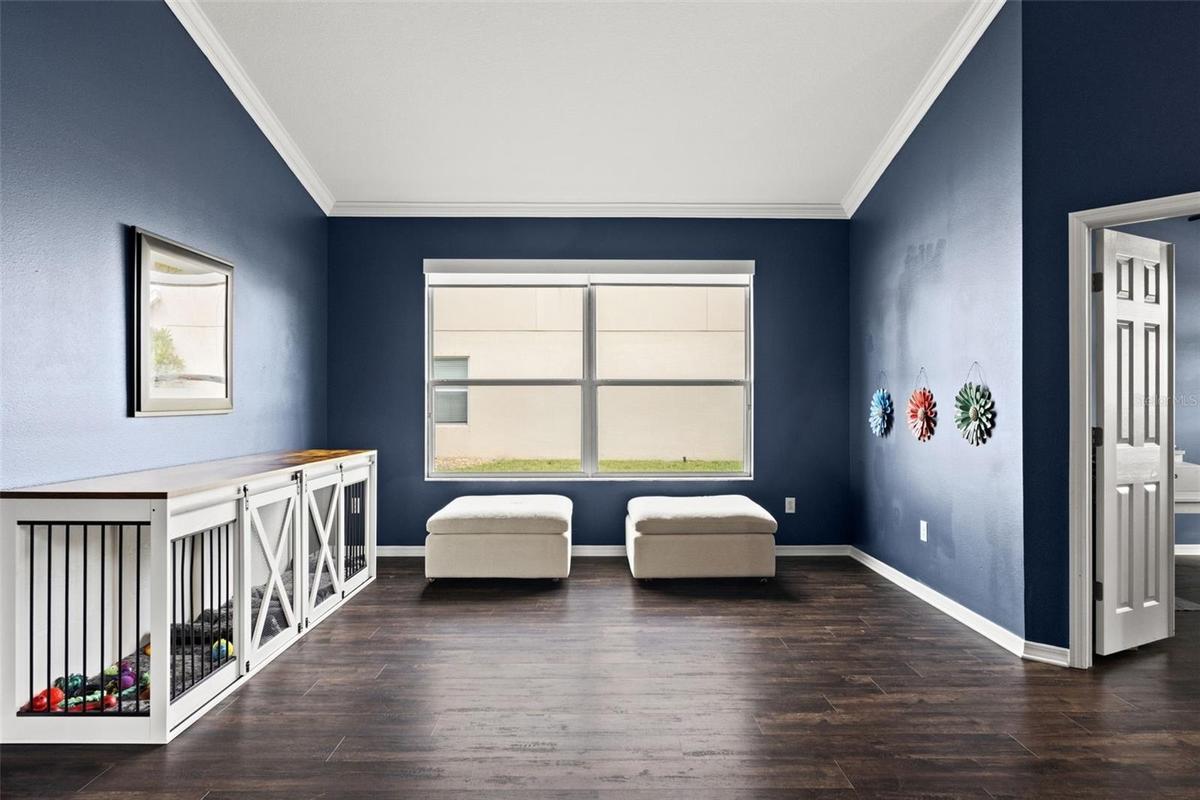 Large front windows fill this versatile living space with natural light while the open layout keeps the home feeling connected.