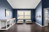 Large front windows fill this versatile living space with natural light while the open layout keeps the home feeling connected.