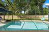 The screened saltwater pool is the centerpiece of this private backyard retreat, ready for sunny afternoons and weekend swims.