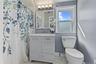 Second floor Bathroom featuring a single-sink vanity with cabinet storage, hexagon-patterned floor tiling, and a window