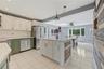 Open Kitchen featuring white shaker-style upper cabinetry, olive green lower cabinetry, stainless steel appliances, a center island that seats 2-3 wit