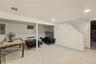 Finished lower level space featuring recessed lighting, holds endless possibilities with its  tile flooring
