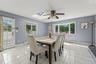 Skylight, ceiling fan,  door to the yard and garage access, tiled flooring, and multiple windows including a large bay window and wall mounted air con