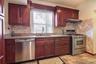 Kitchen featuring stainless steel appliances, exquisite Cherry cabinets, and tiled floor