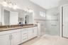Taupe quartz and wide-spread faucets add a touch of elegance to the double vanity ensuite bath.  Private water-closet area.