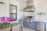 The  summer kitchen is well equipped with a vented gas grill, sink and small refrigerator