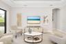 The great room is defined by a tall tray ceiling with crown molding.