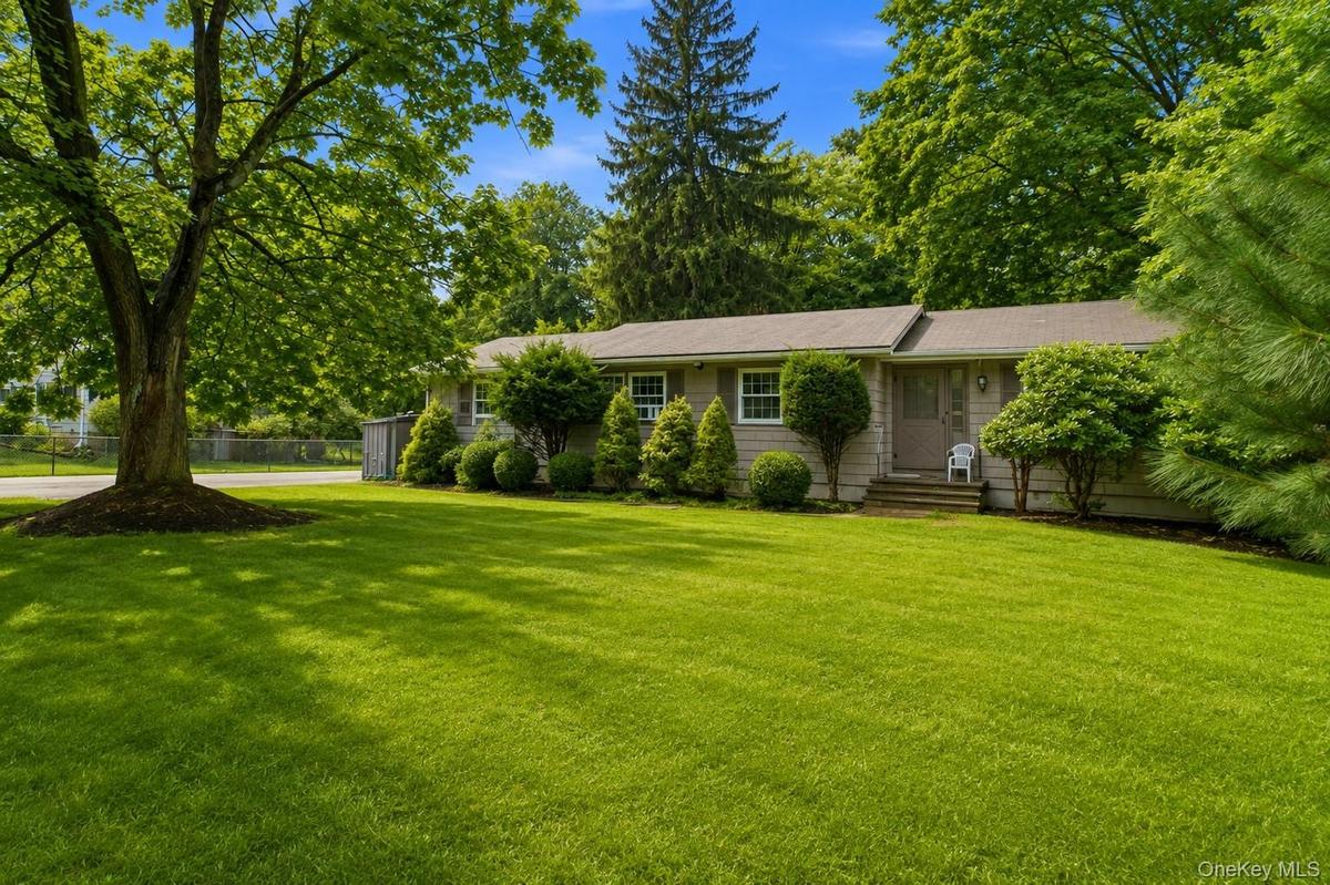 Expansive front lawn with mature trees and established landscaping