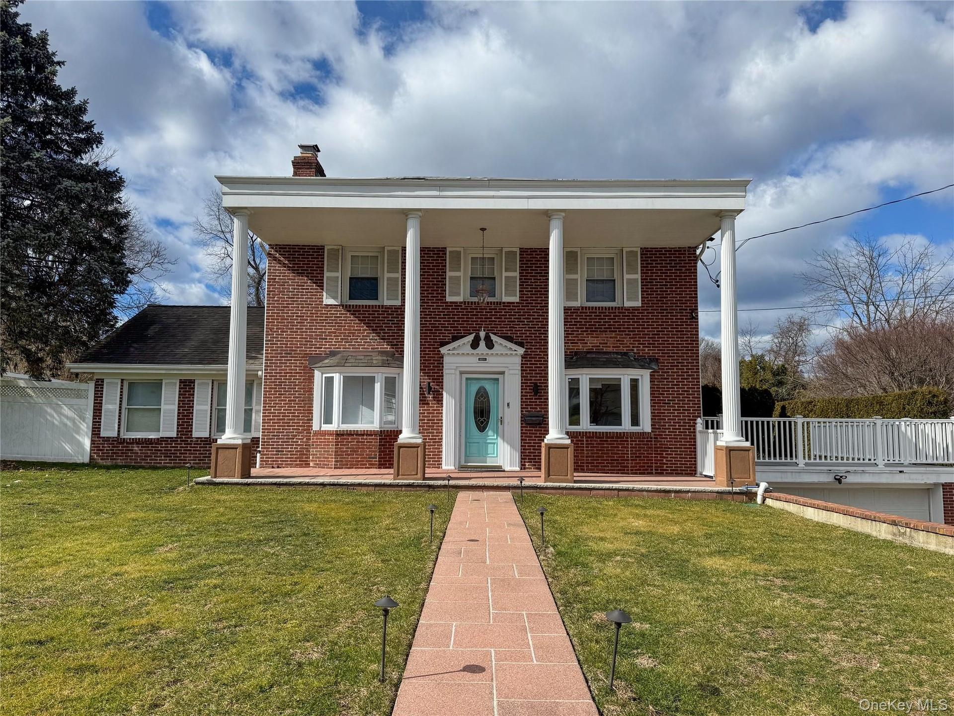 Brick exterior featuring white columned portico