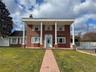 Brick exterior featuring white columned portico