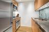 Kitchen with decorative backsplash, baseboards, appliances with stainless steel finishes, a sink, and light wood-style floors