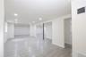 Open-concept lower level with recessed lighting, light-toned tile flooring, and white painted walls