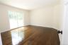 Hardwood flooring, recessed lighting, sliding glass door, white trim, and a matte black door handle