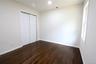 Hardwood flooring, recessed lighting, white trim, white walls, and a window providing natural illumination