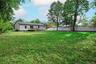 Expansive green lawn with a white privacy fence