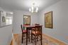 Hardwood flooring, neutral wall paint, and a contemporary chandelier