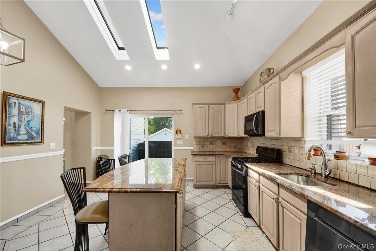 Open updated kitchen with skylights and access to side deck