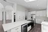 Well-appointed kitchen island featuring a wine refrigerator, microwave, range, additional cabinet storage and breakfast bar seating.