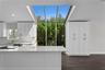 Floor-to-ceiling windows fill the gorgeous kitchen with natural light, complemented by abundant cabinet storage.