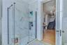 Glass-enclosed shower with subway tile surround, matte black shower fixtures, and integrated shelving