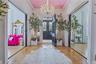 Grand entryway featuring a decorative chandelier, dual paneled doors, and light wood-finish flooring with intricate inlay