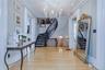 Wood-finish flooring, a curved staircase with dark wood treads, and white balusters