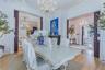 Ornate chandelier, decorative crown molding, light wood-finish flooring, and pocket doors