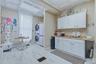 White wood-finish flooring, white cabinetry, integrated sink, and patterned ceiling panels