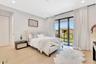 Comfortable bedroom with wide-plank flooring, recessed lighting, and a calm, neutral palette.