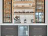 Custom built-in bar featuring integrated refrigeration, accent lighting, and display shelving—ideal for entertaining.