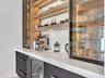 Custom built-in bar featuring integrated refrigeration, accent lighting, and display shelving—ideal for entertaining.