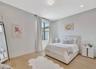 Generously sized bedroom with neutral finishes, abundant natural light, and flexible space for guests or family.