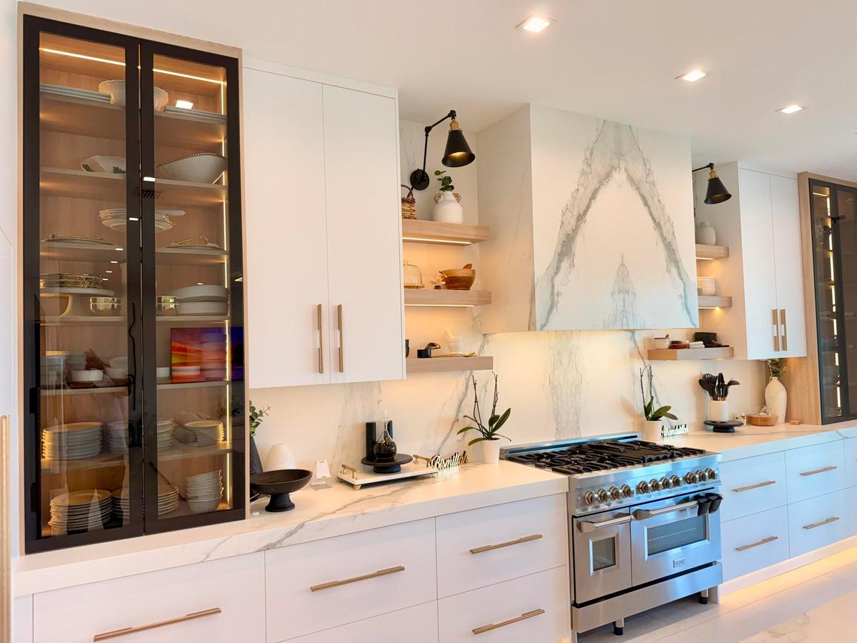 High-end appliance package with custom cabinetry, porcelain slab backsplash, and thoughtful lighting details.