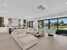 Spacious living area featuring clean modern finishes, recessed lighting, and seamless flow to the kitchen and dining spaces.