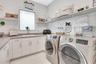 Well-appointed laundry room with custom cabinetry, ample counter space, and modern appliances.