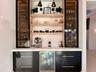 Custom built-in bar featuring integrated refrigeration, accent lighting, and display shelving—ideal for entertaining.