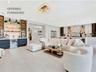 Spacious living area featuring clean modern finishes, recessed lighting, and seamless flow to the kitchen and dining spaces.