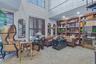 Two-story room featuring extensive built-in wooden shelving, dark wood plantation shutters, and a spiral staircase