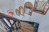 Staircase featuring dark wood banister and balusters, painted risers, and decorative wall mirrors