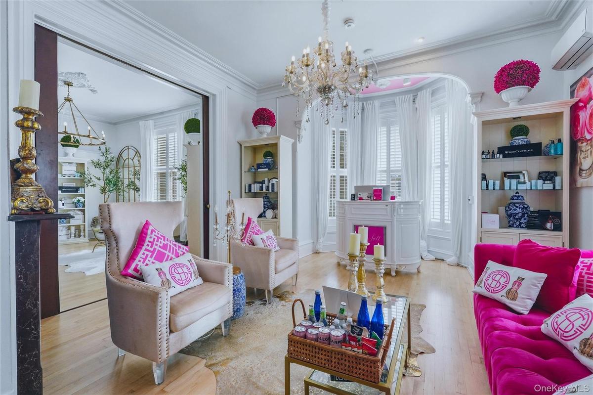 Hardwood flooring, ornate chandelier, decorative crown molding, built-in shelving, and large windows with plantation shutters