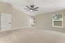 Primary bedroom with brand new carpet and ceiling fan