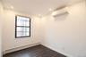 Recessed ceiling lighting, dark wood-finish flooring, and a wall-mounted mini-split HVAC unit