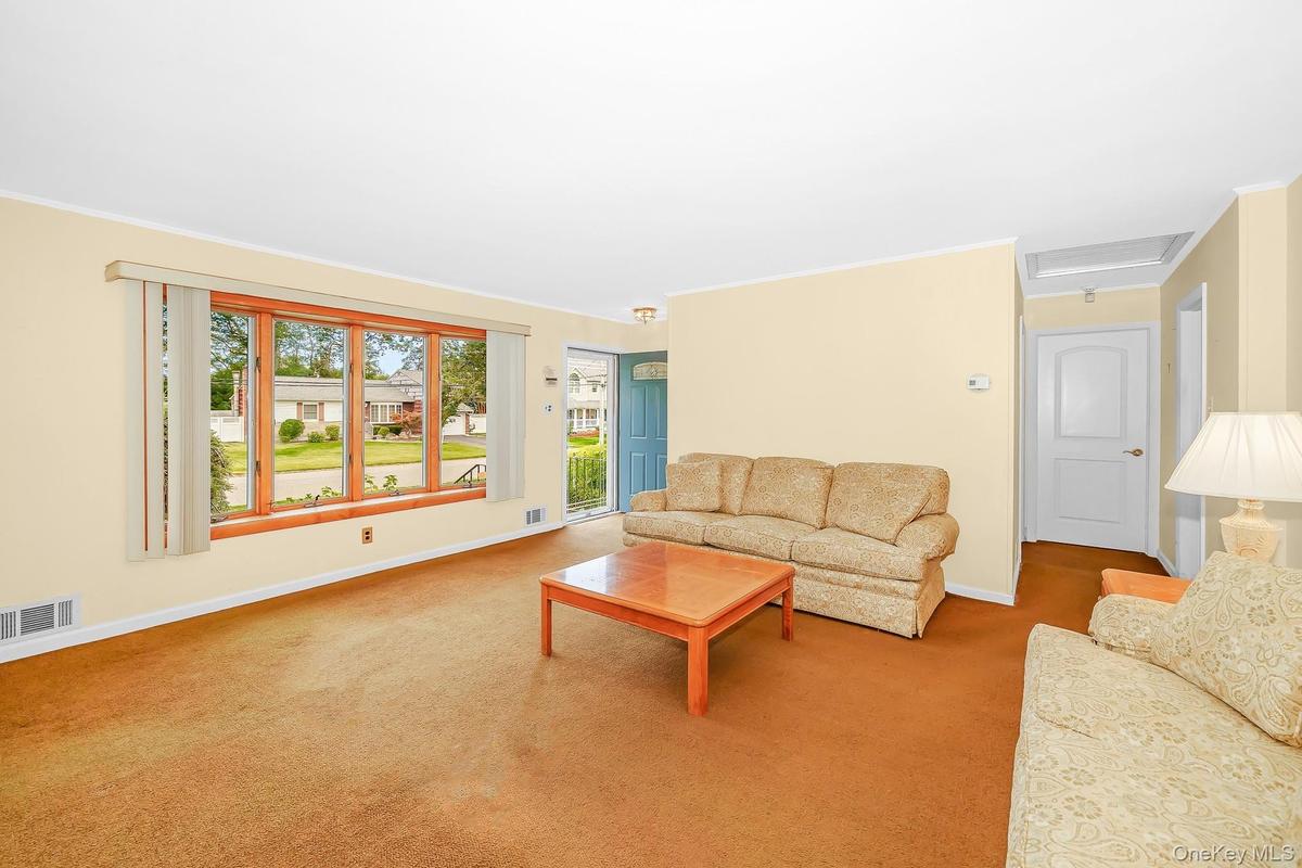 With large bay window and carpeting