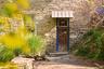 Doorway to property with stone siding, a standing seam roof, and a metal roof