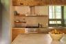Kitchen featuring range hood, open shelves, stainless steel appliances, light countertops, and modern cabinets