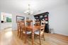 Wood-finish flooring, and a decorative chandelier.