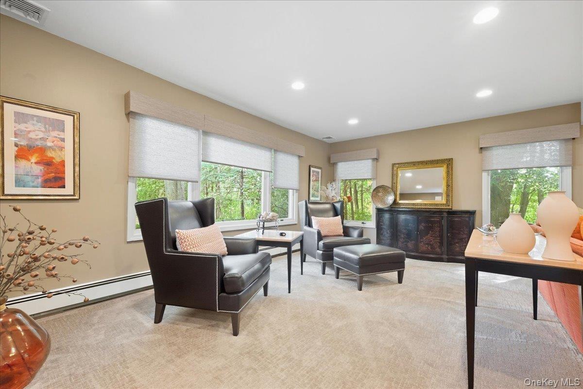 Recessed lighting illuminates neutral-toned walls and plush carpeting Of this Large Family Room with Gas Fireplace
